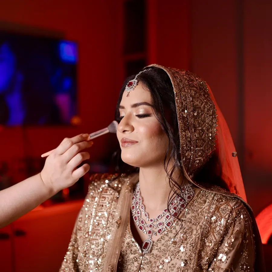 A makeup brush applying lip colour during an engagement makeup session